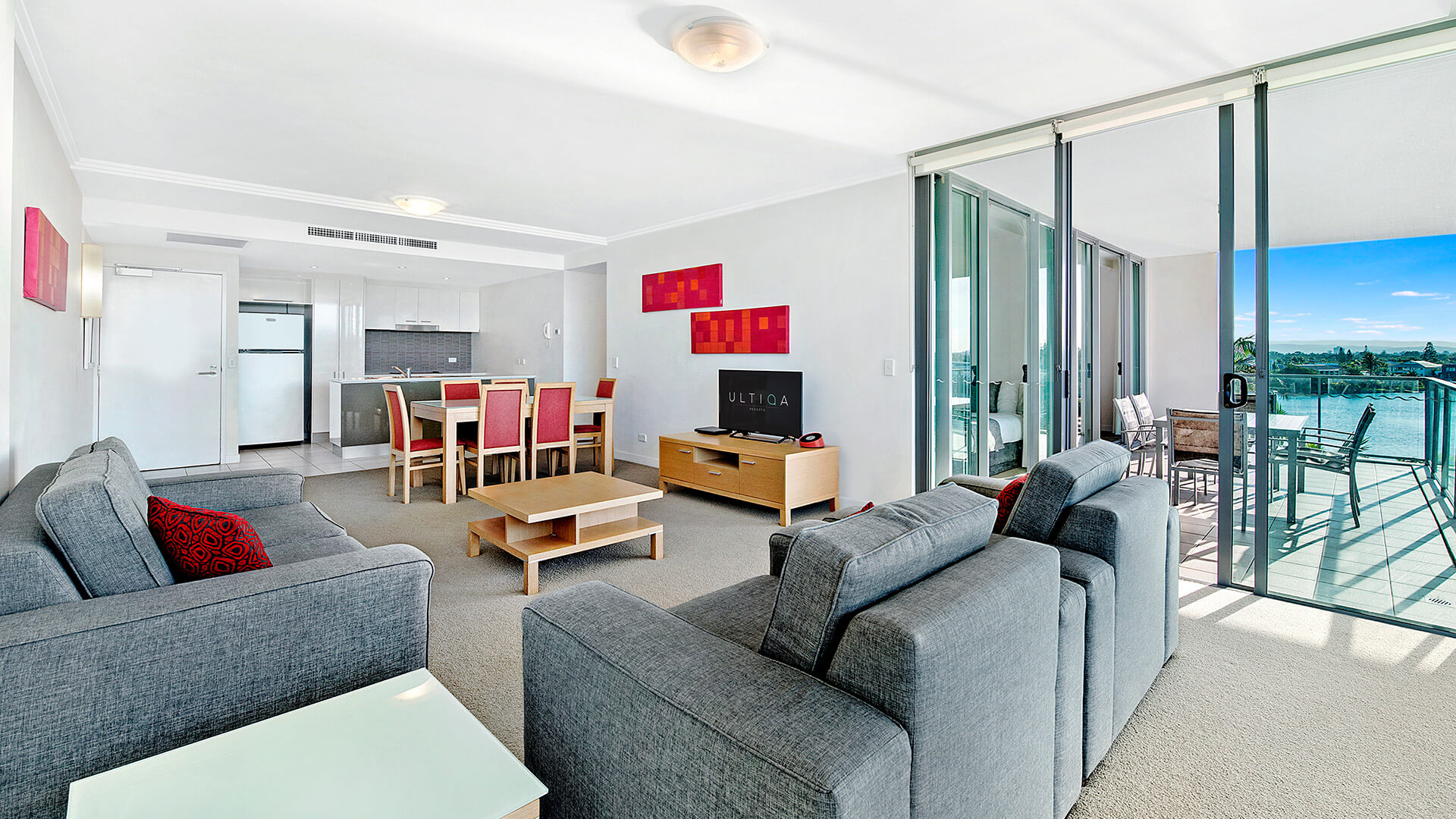 Open-plan living, dining, and kitchen area in the 2 Bedroom Apartment at ULTIQA Freshwater Point Resort with balcony access and water views.