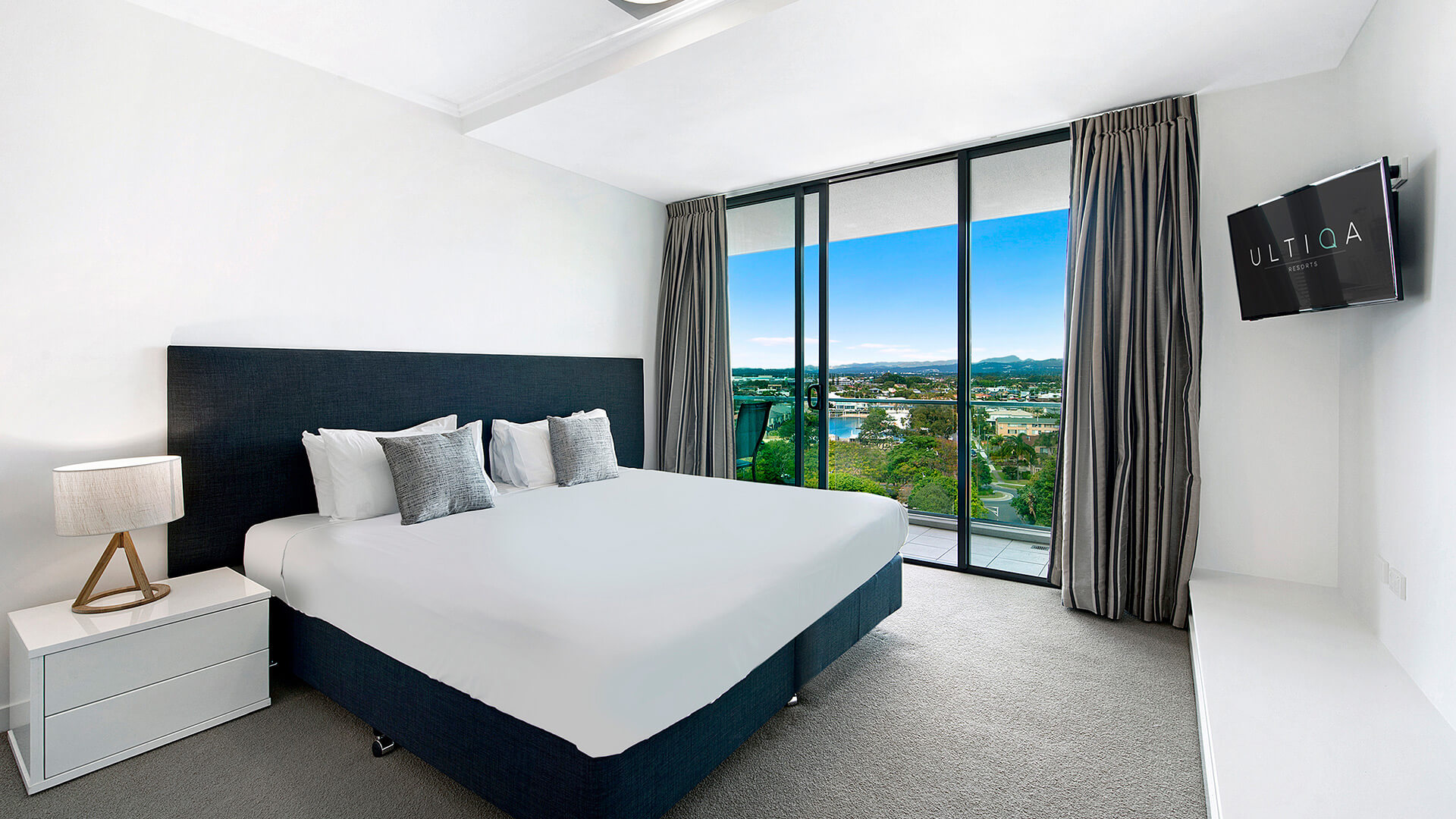 Master bedroom with king bed, private balcony access, and hinterland views in the 3 Bedroom Apartment at ULTIQA Freshwater Point Resort.