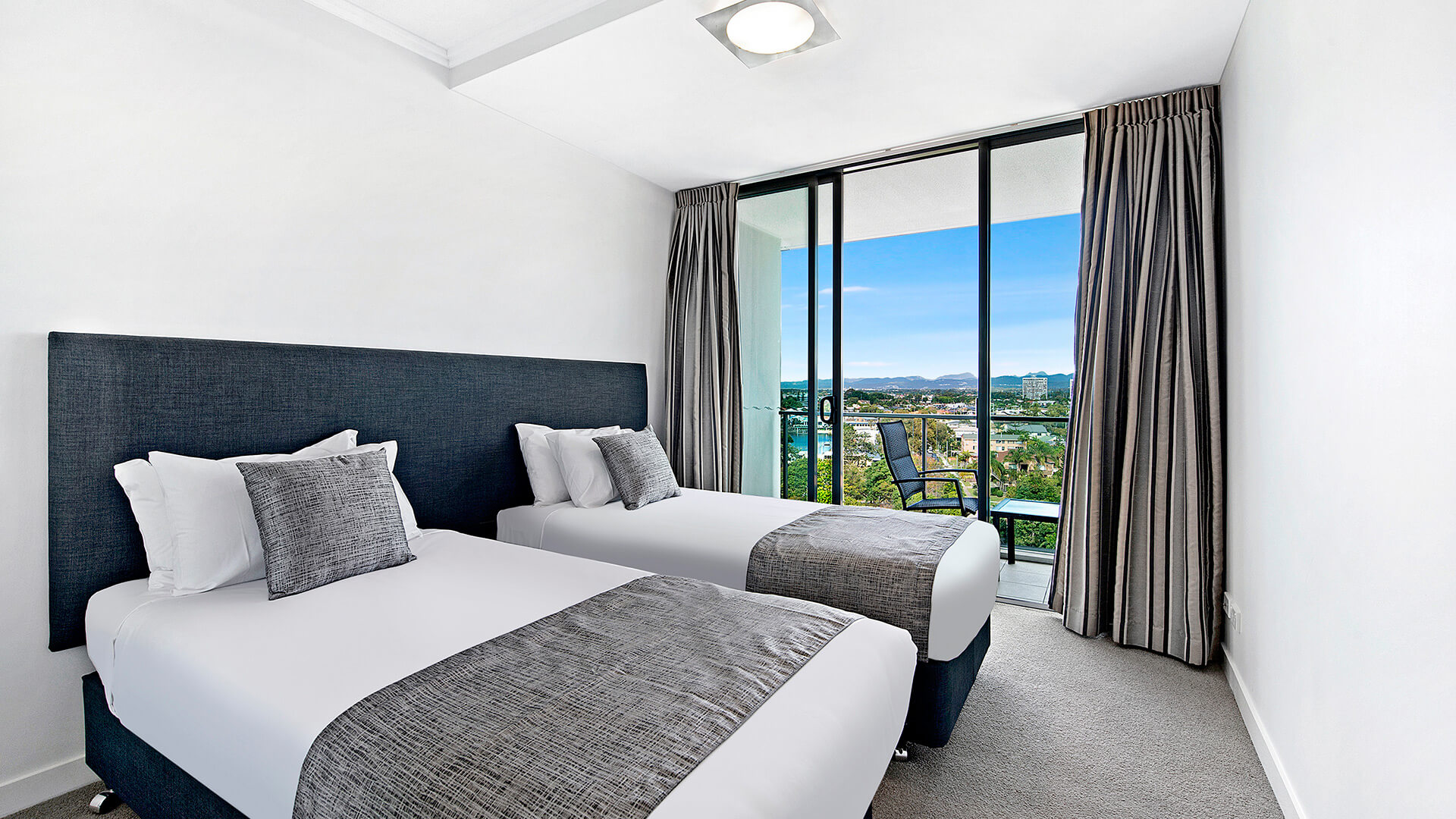 Twin bedroom with private balcony and hinterland views in the 3 Bedroom Apartment at ULTIQA Freshwater Point Resort.