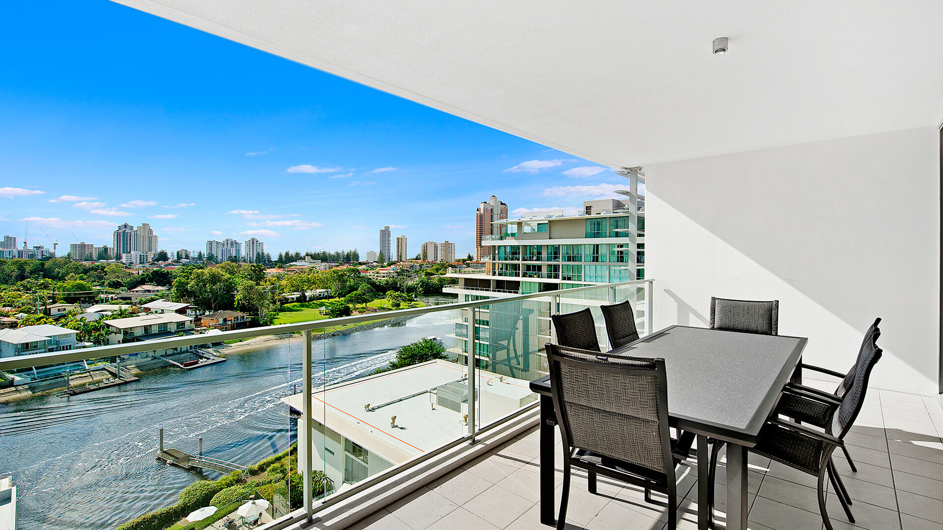 Private balcony with outdoor dining and waterway views from the 3 Bedroom Apartment at ULTIQA Freshwater Point Resort.