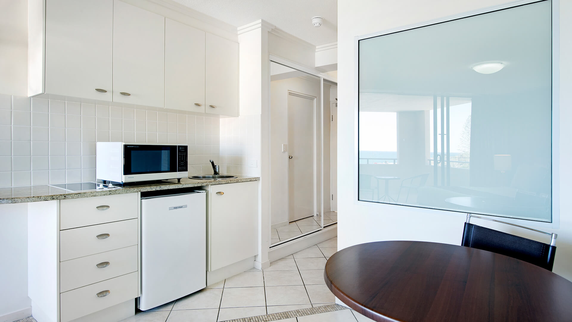 Open-plan Studio with queen bed, dining area, and private balcony offering ocean views at ULTIQA Shearwater Resort.