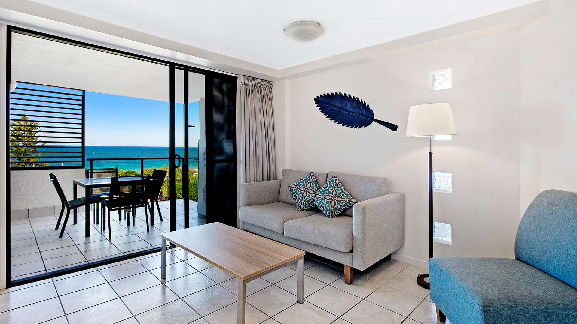 Living area with ocean-view balcony in 1 Bedroom Apartment at ULTIQA Shearwater Resort.