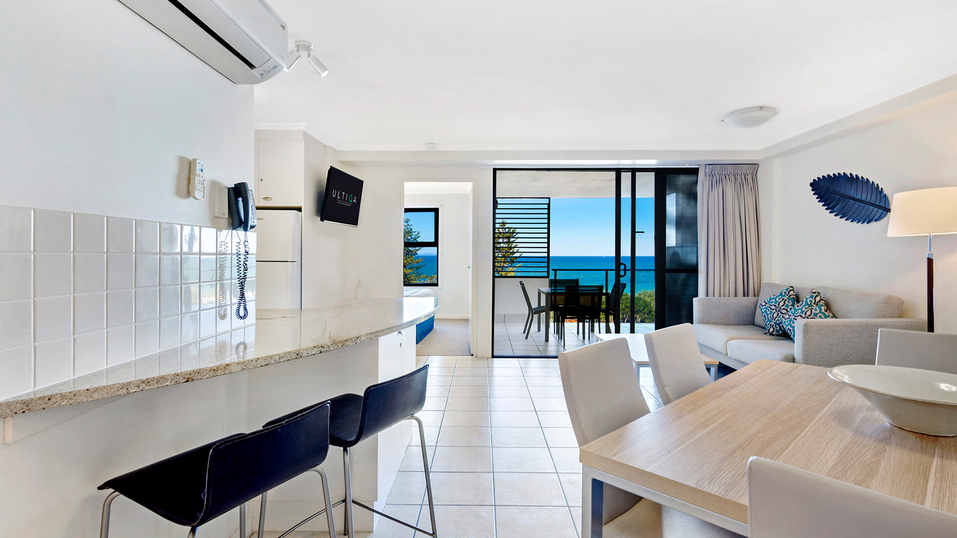 Open-plan kitchen, dining, and living area with ocean views in 1 Bedroom Apartment at ULTIQA Shearwater Resort.
