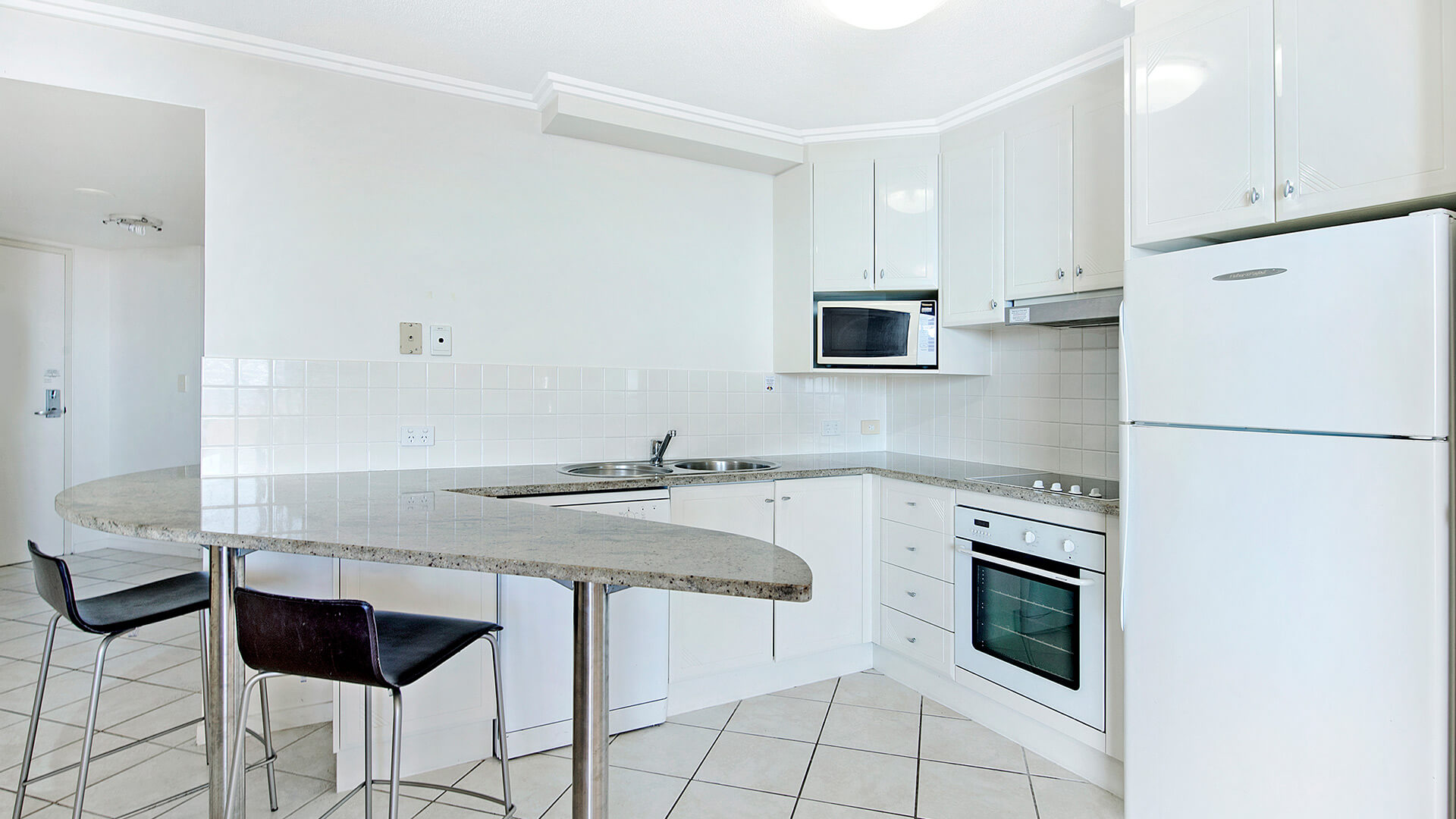 Full kitchen with breakfast bar seating in 2 Bedroom 1 Bathroom Apartment at ULTIQA Shearwater Resort.