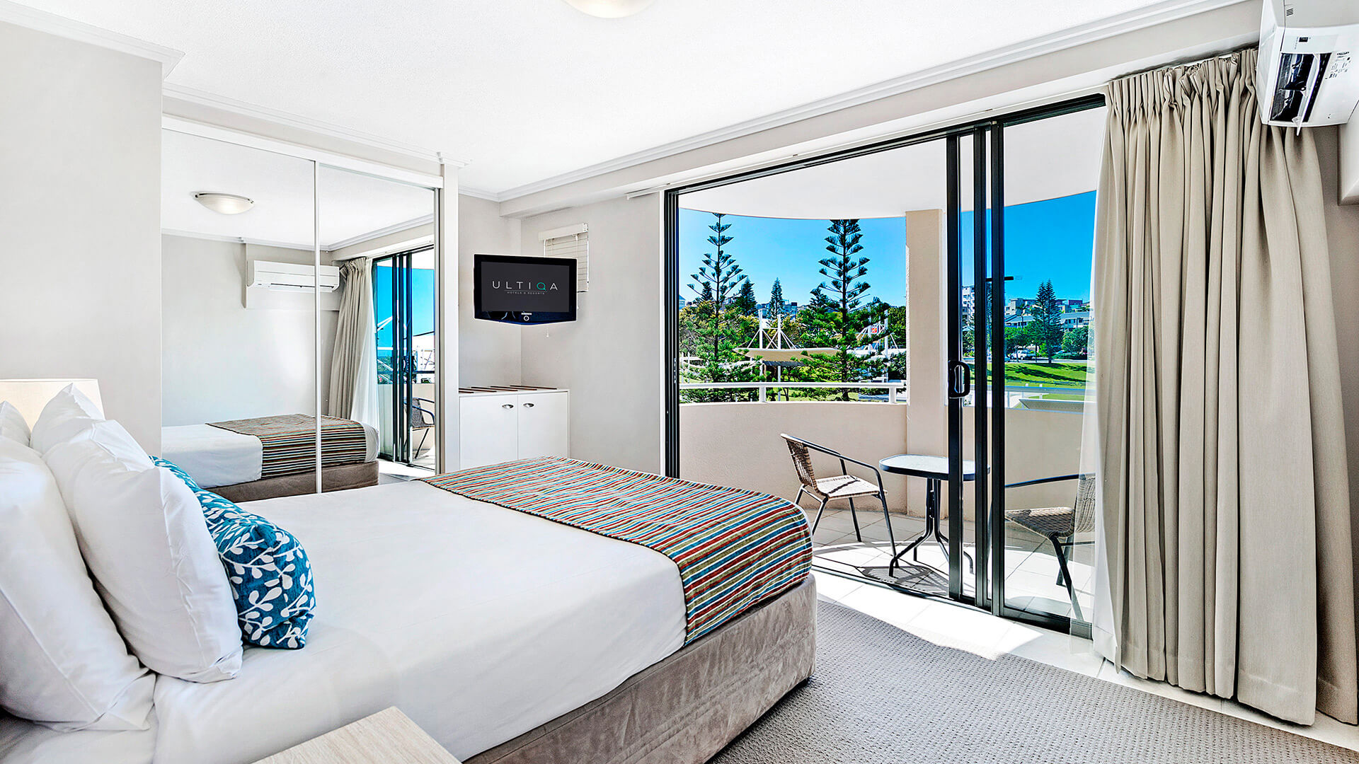 Bedroom with private balcony access and outdoor seating in 3 Bedroom Dual Key Apartment at ULTIQA Shearwater Resort.