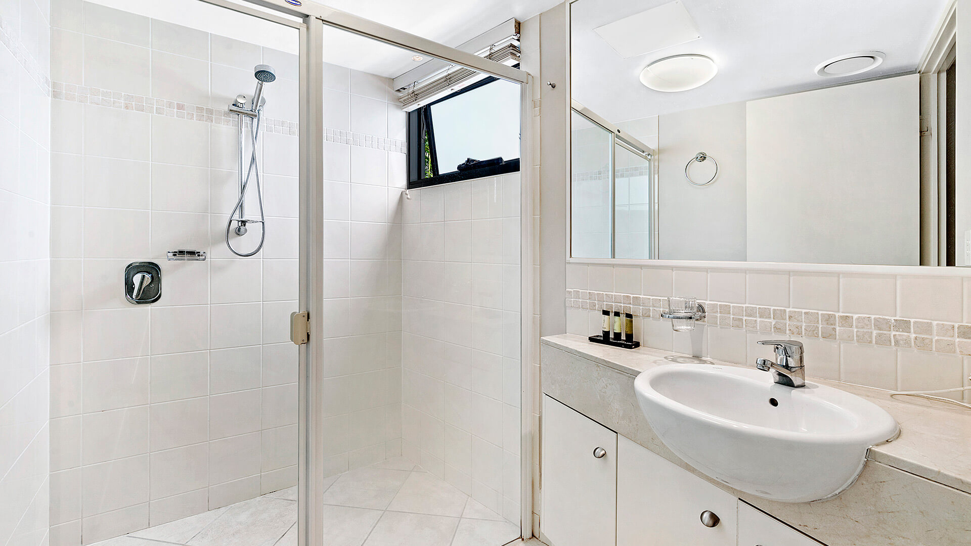 Bathroom with glass-enclosed shower and vanity in 3 Bedroom Dual Key Apartment at ULTIQA Shearwater Resort.