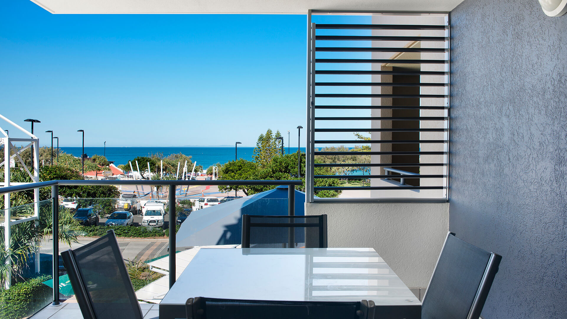 Private balcony with outdoor dining and ocean views in 3 Bedroom Dual Key Apartment at ULTIQA Shearwater Resort.