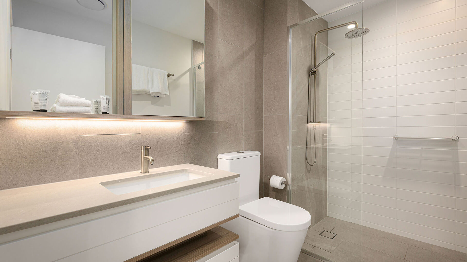 Modern bathroom with vanity, mirror cabinet, and walk-in shower in 1 Bedroom Ocean View Suite at ULTIQA Signature at Broadbeach.