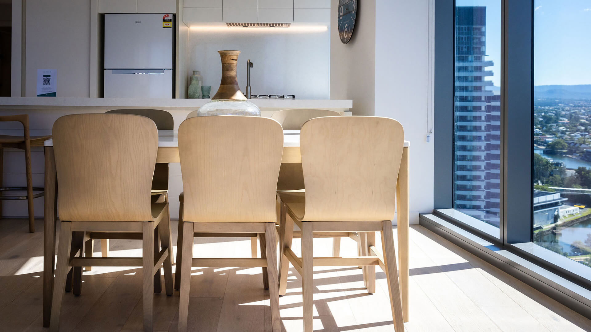 Dining table and chairs with city views in 2 Bedroom Ocean View Suite Premium at ULTIQA Signature at Broadbeach.