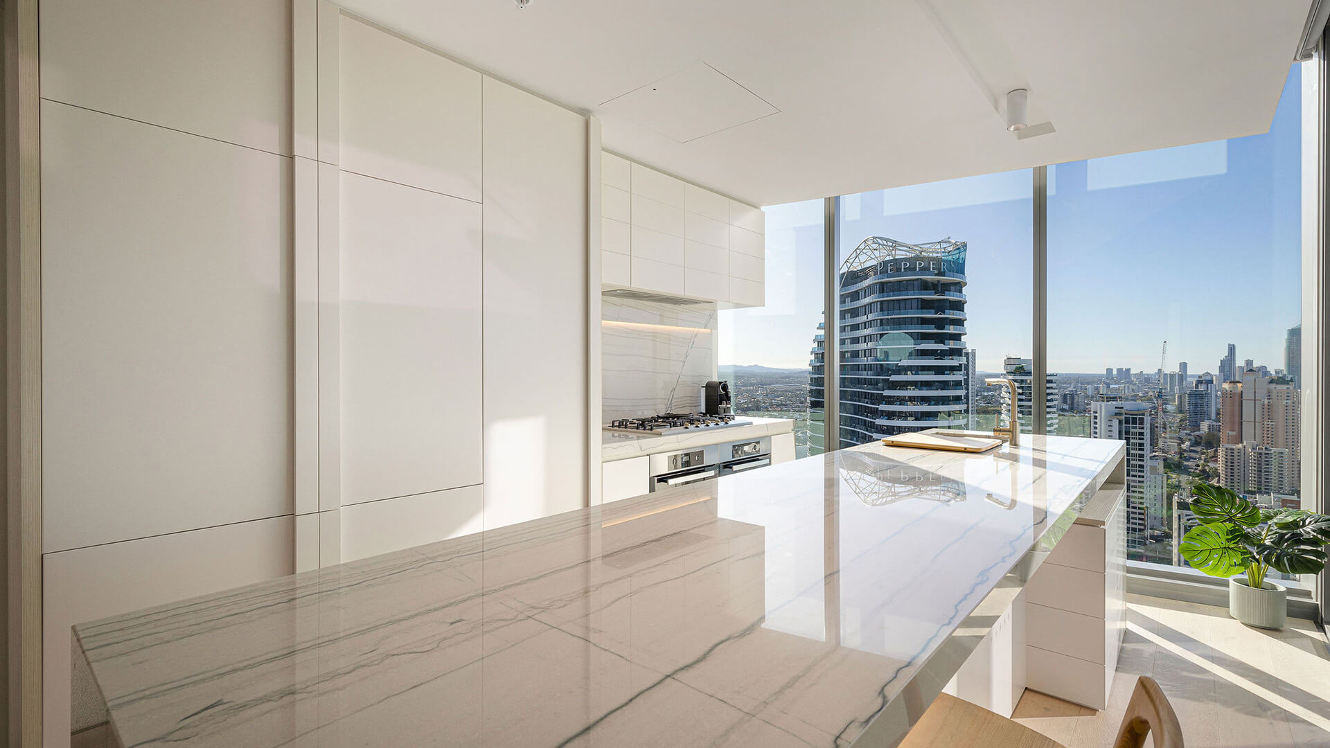 Modern kitchen in the 3 Bedroom Ocean View Suite at ULTIQA Signature at Broadbeach, featuring city and ocean views.
