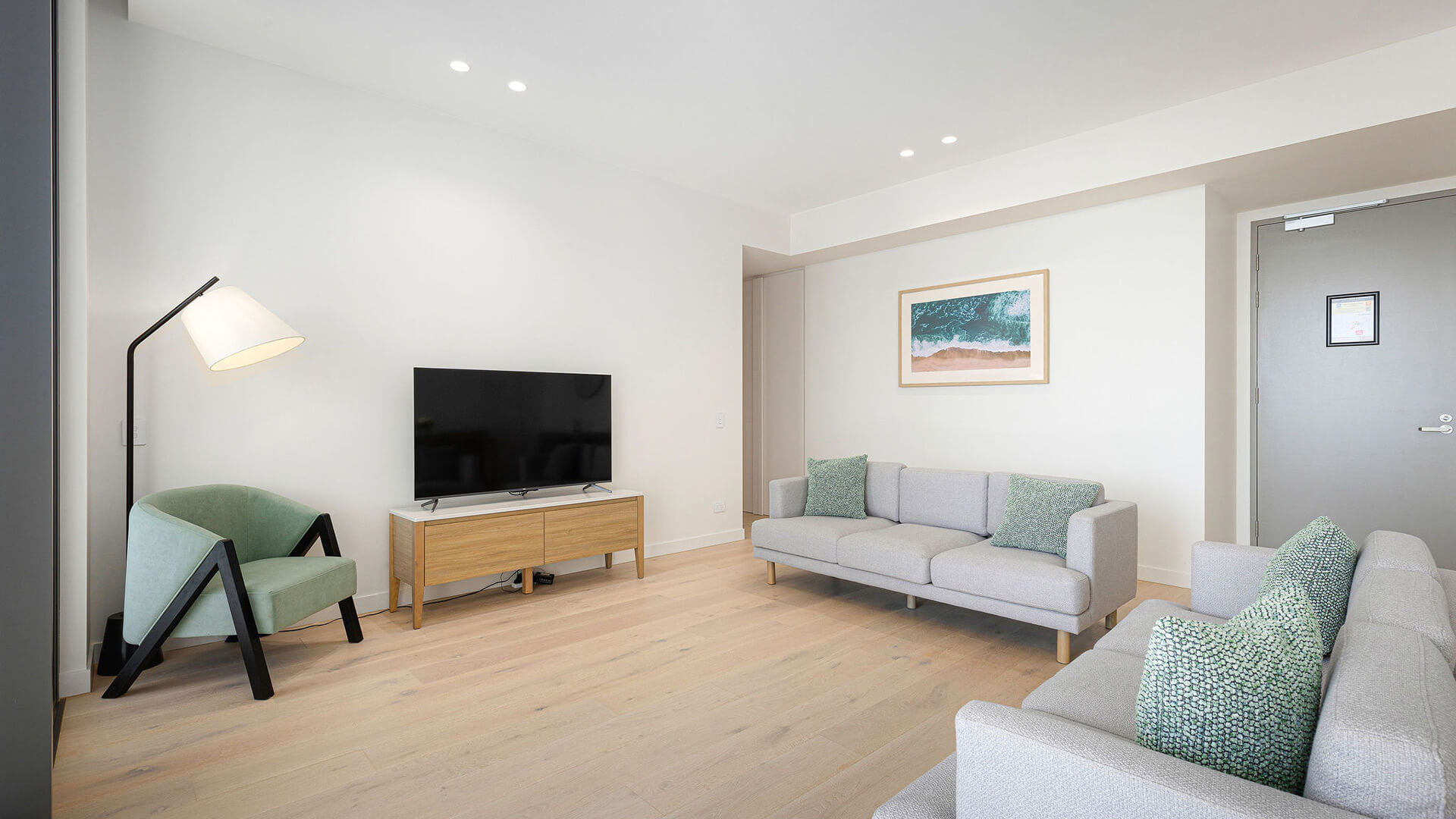 Living area in the 3 Bedroom Ocean View Suite at ULTIQA Signature at Broadbeach with modern seating and flat-screen TV.